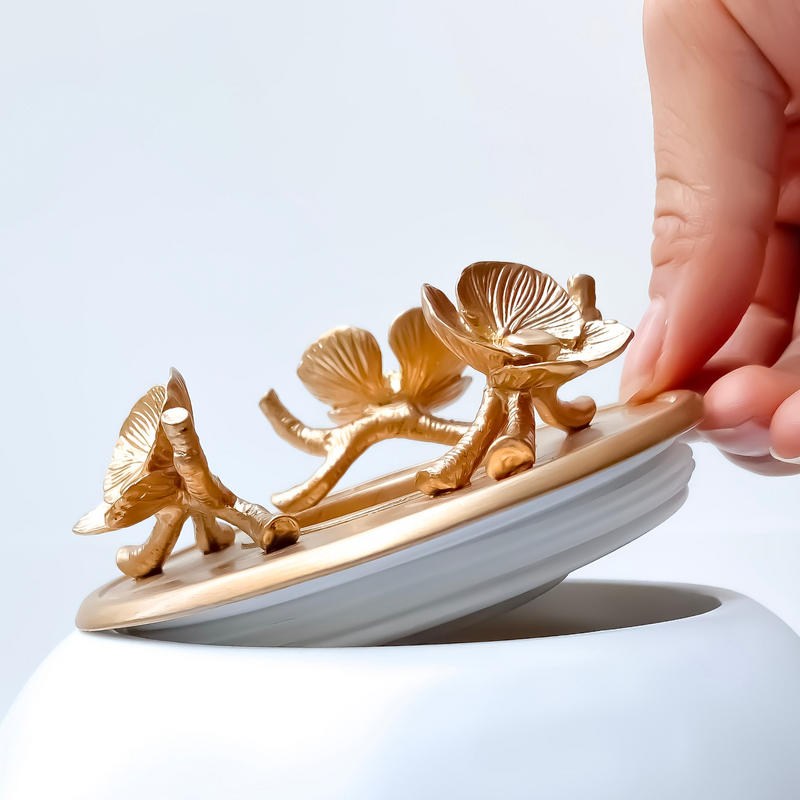 white urn for ashes with gold floral lid by gnight fetcher