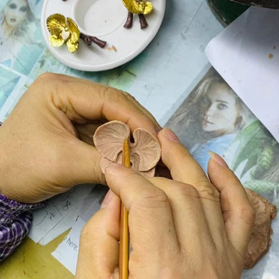 hand of a man sculpturing an orchid